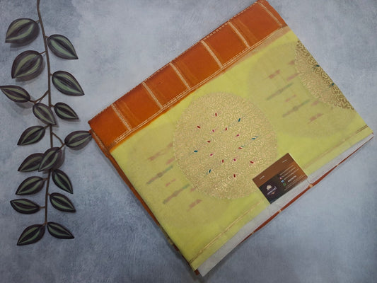 Book with a yellow cover featuring tree illustrations on a gray surface.