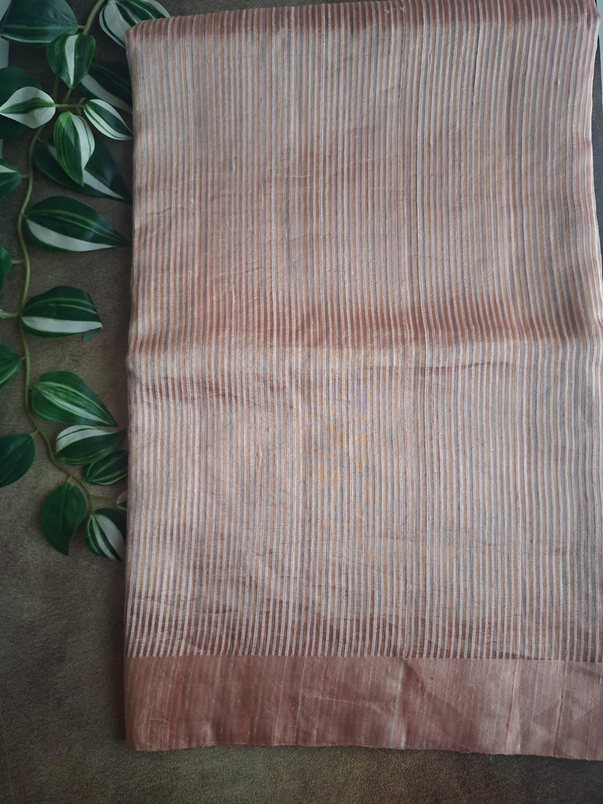 Textured fabric with a subtle pattern on a dark surface with green leaves.