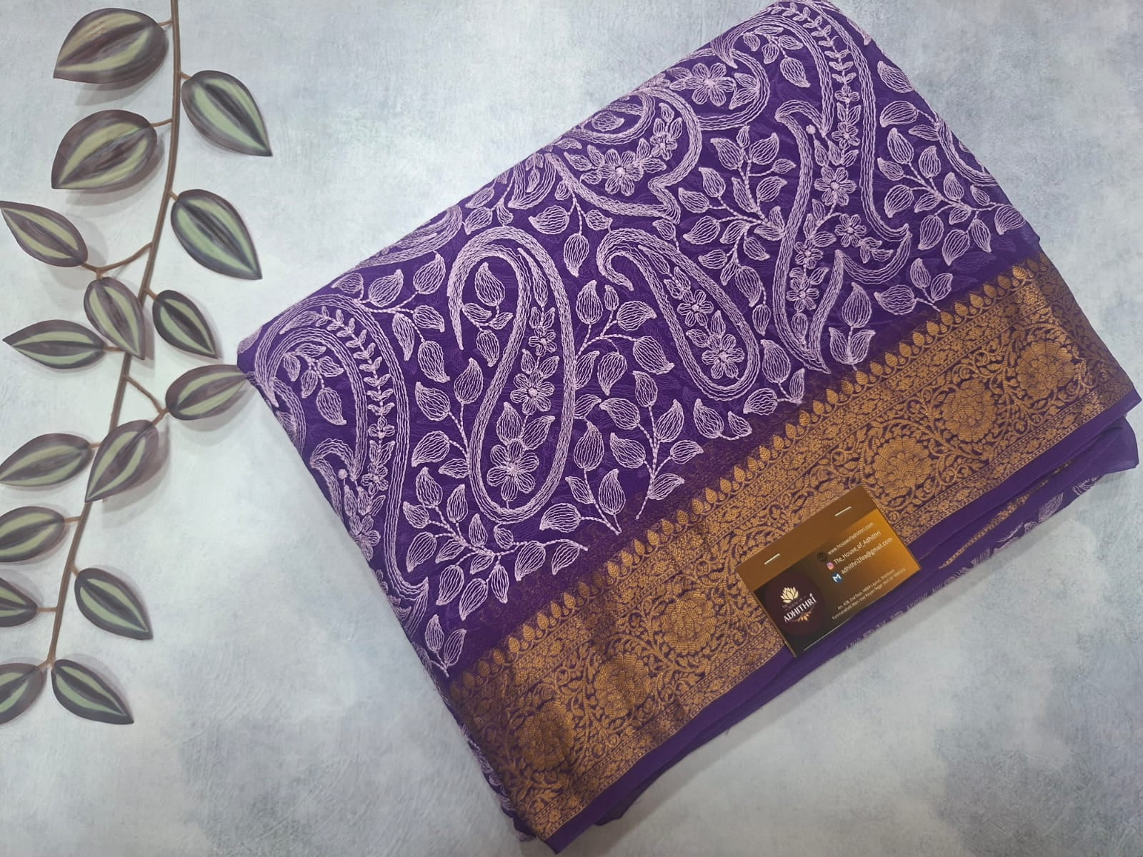 Purple fabric with gold and white patterns on a light gray background