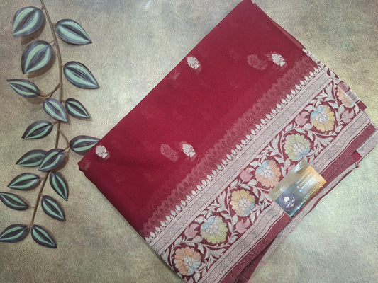 Red saree with floral patterns on a textured surface