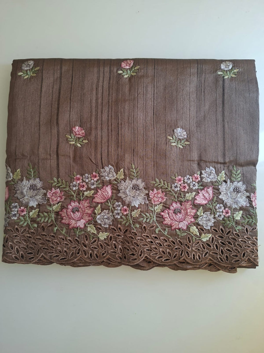 Brown fabric with floral embroidery on a white background