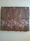 Brown fabric with floral embroidery on a white background