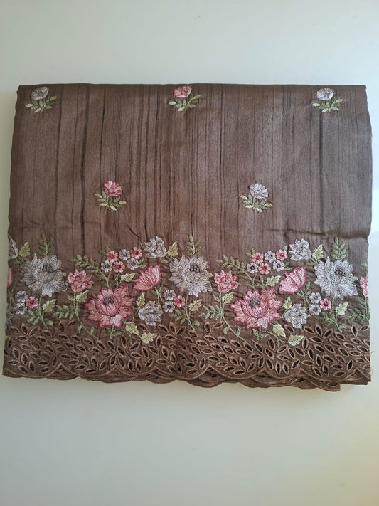 Brown fabric with floral embroidery on a white background