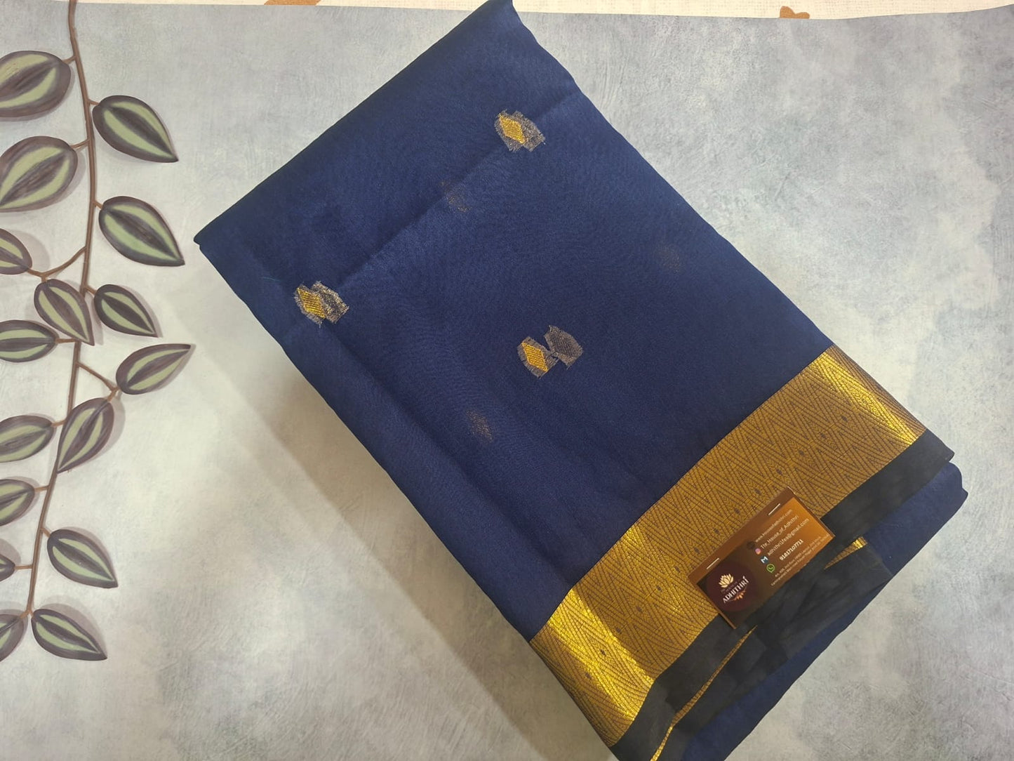 Blue fabric with gold border and embroidery on a textured surface