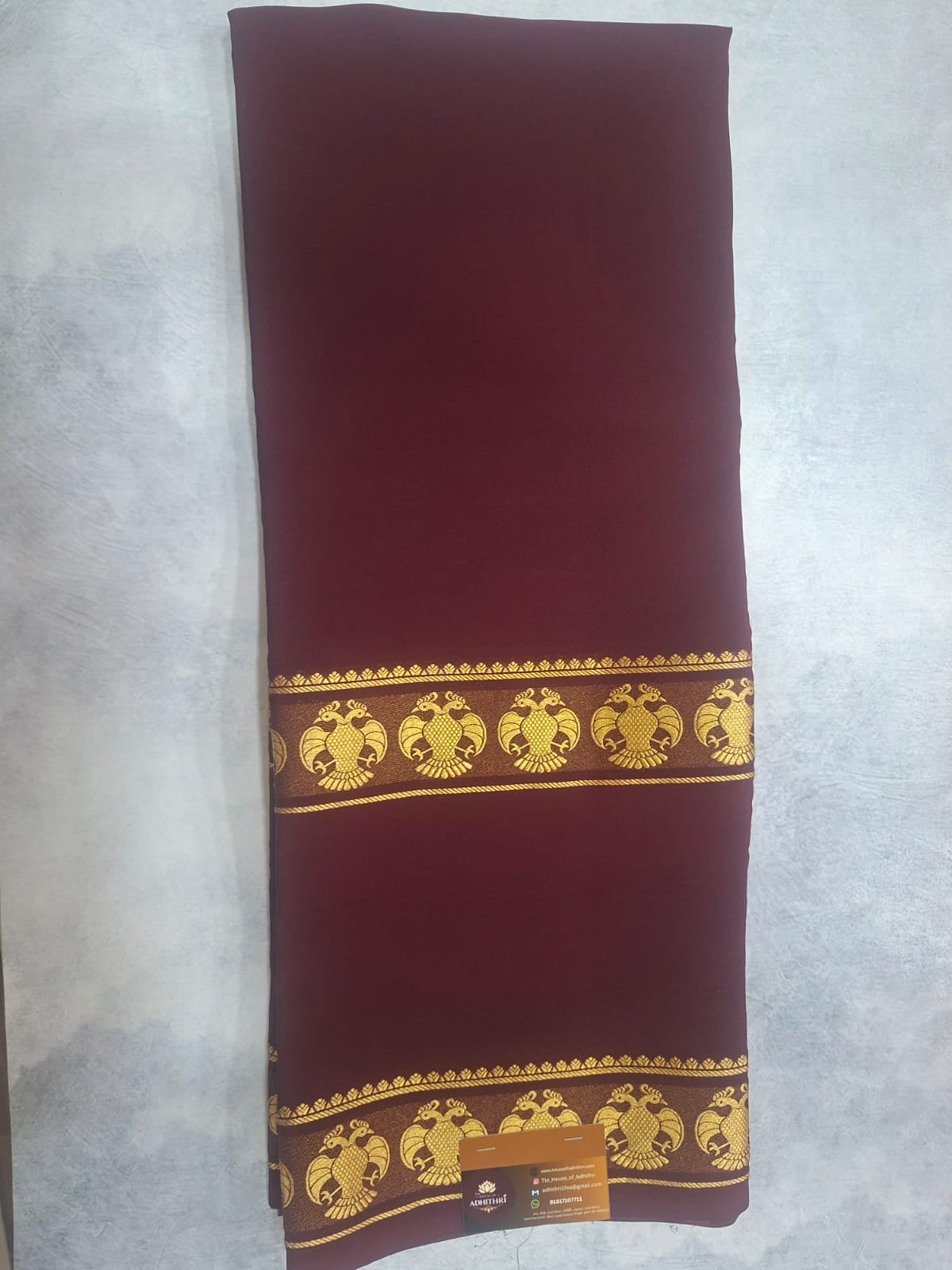 Red pillow with gold decorative patterns on a light gray background