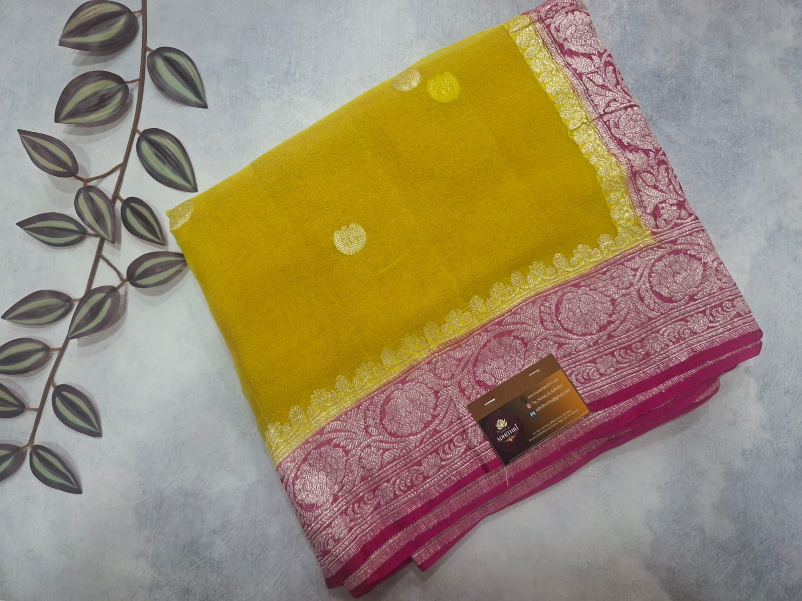 Yellow and pink saree with a floral pattern on a white background