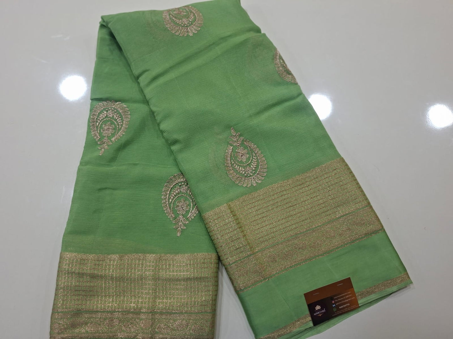 Green fabric with gold embroidery on a white background