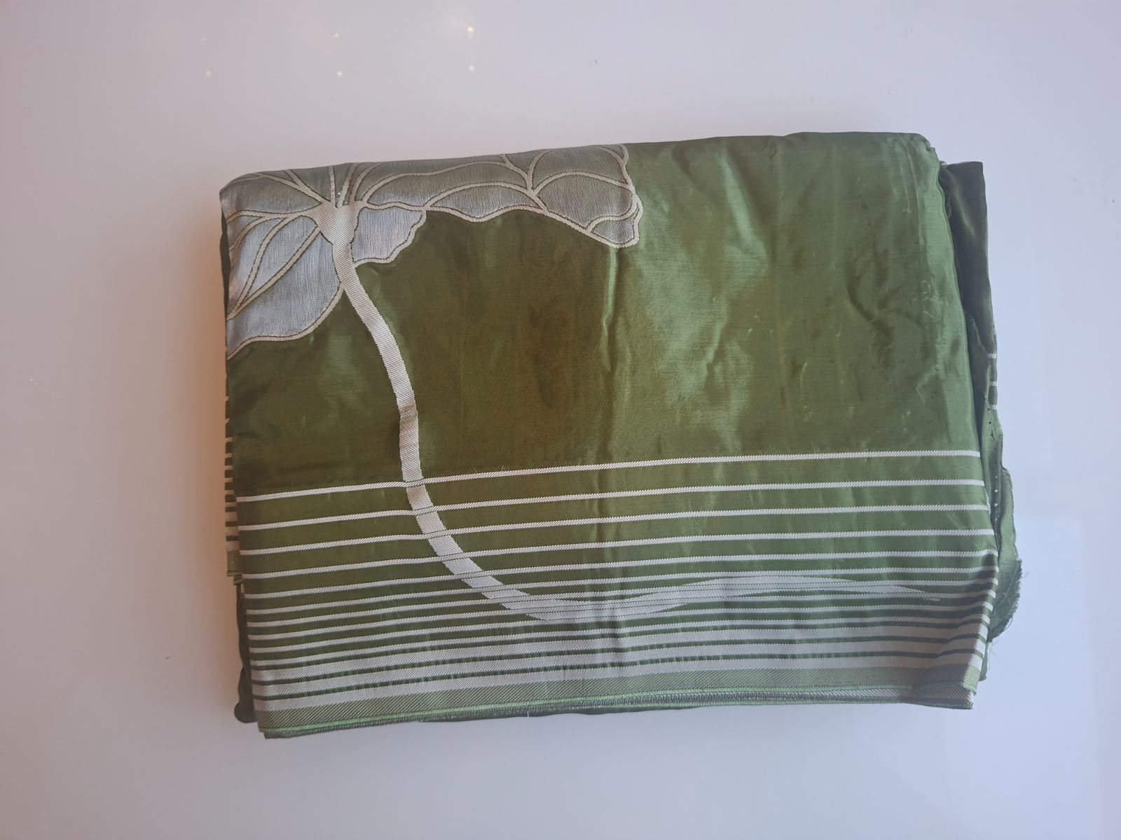 Green fabric with white patterns on a white background