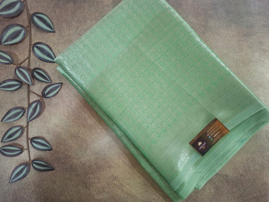 Green textured mat with a brand label on a brown surface with leaf design