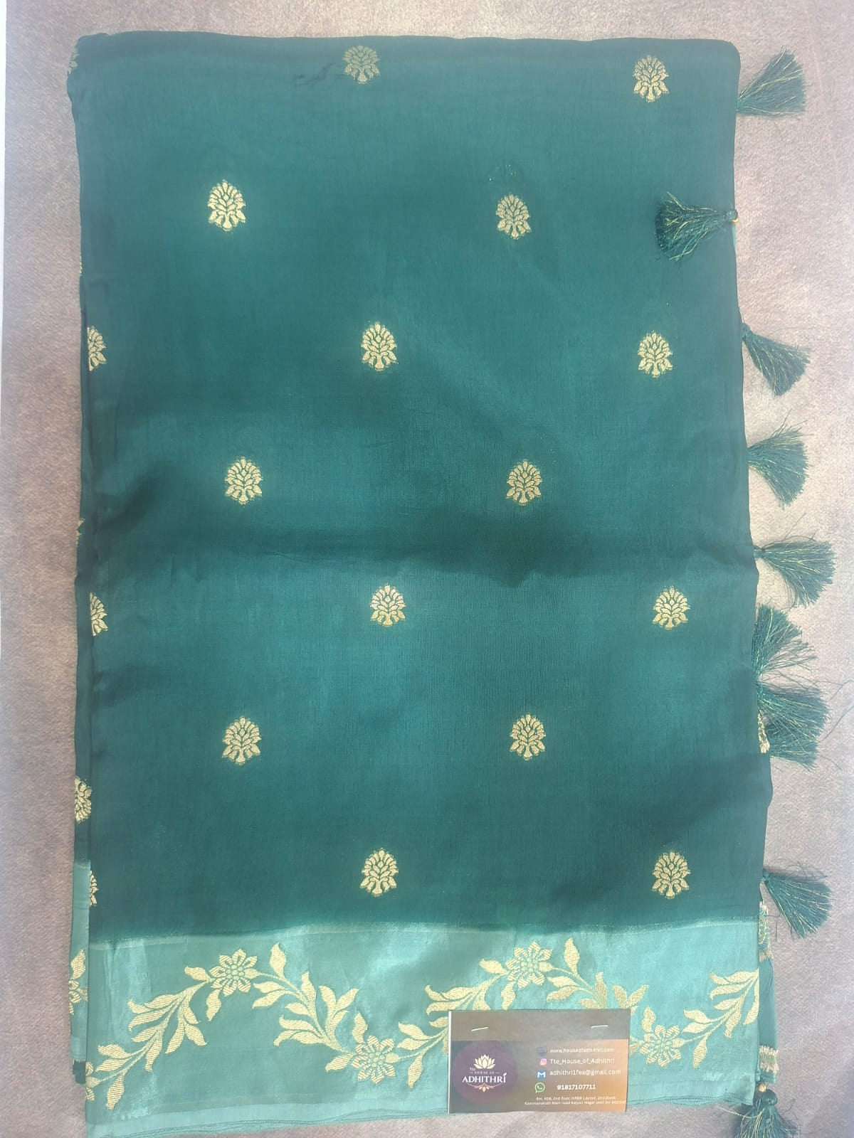 Green scarf with gold floral patterns on a gray surface