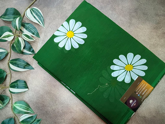 Green mat with white daisy designs on a textured surface with leaves.
