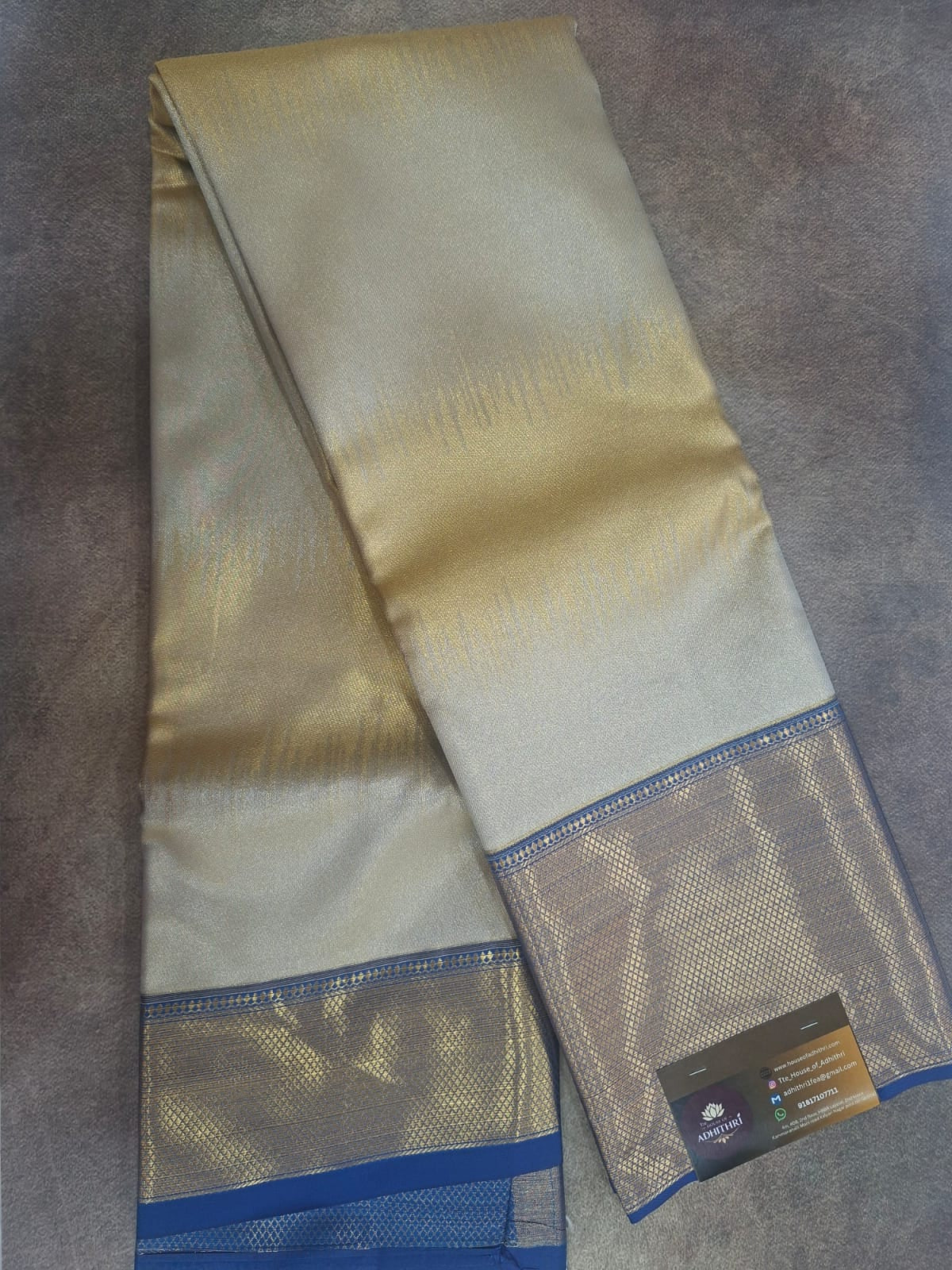 Folded beige fabric with blue edges on a gray surface