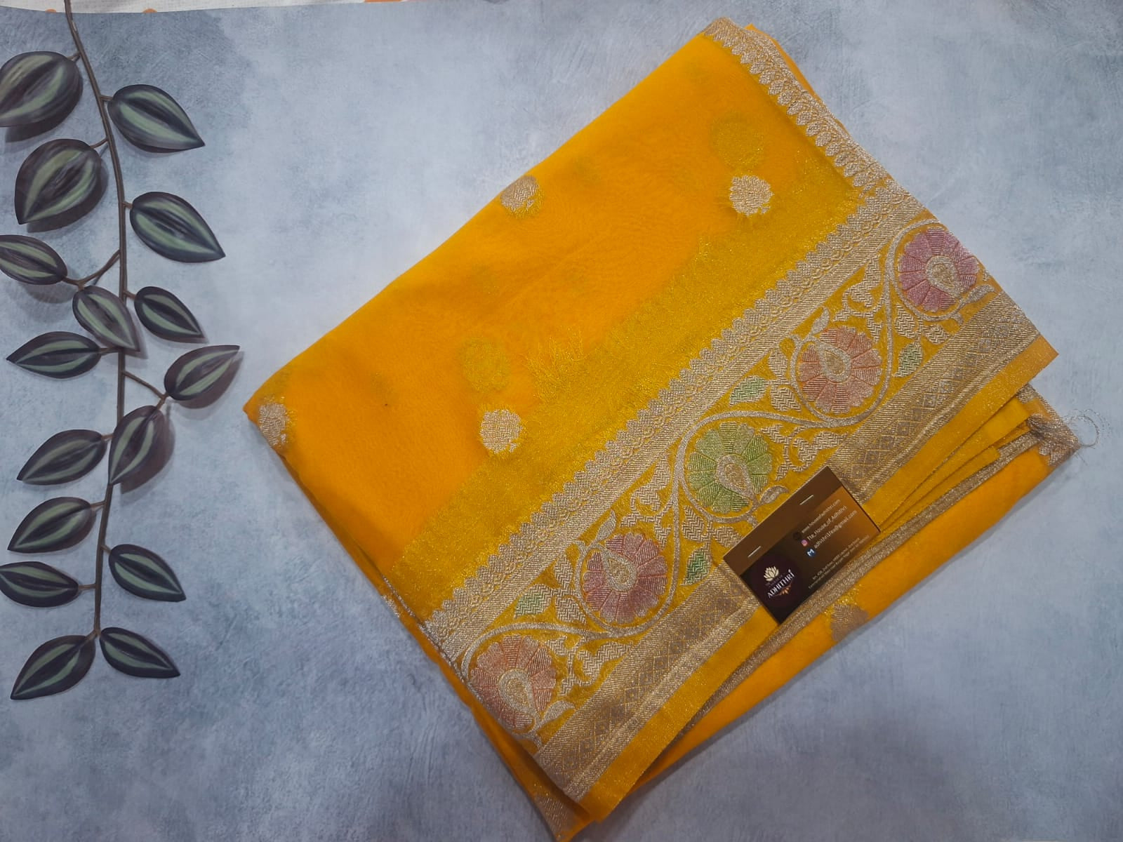 Yellow fabric with intricate patterns on a gray background