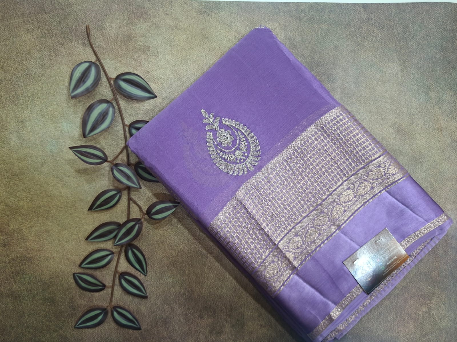 Purple saree with silver embroidery on a textured surface