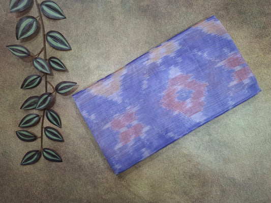 Blue patterned fabric on a textured surface with a decorative leaf design.