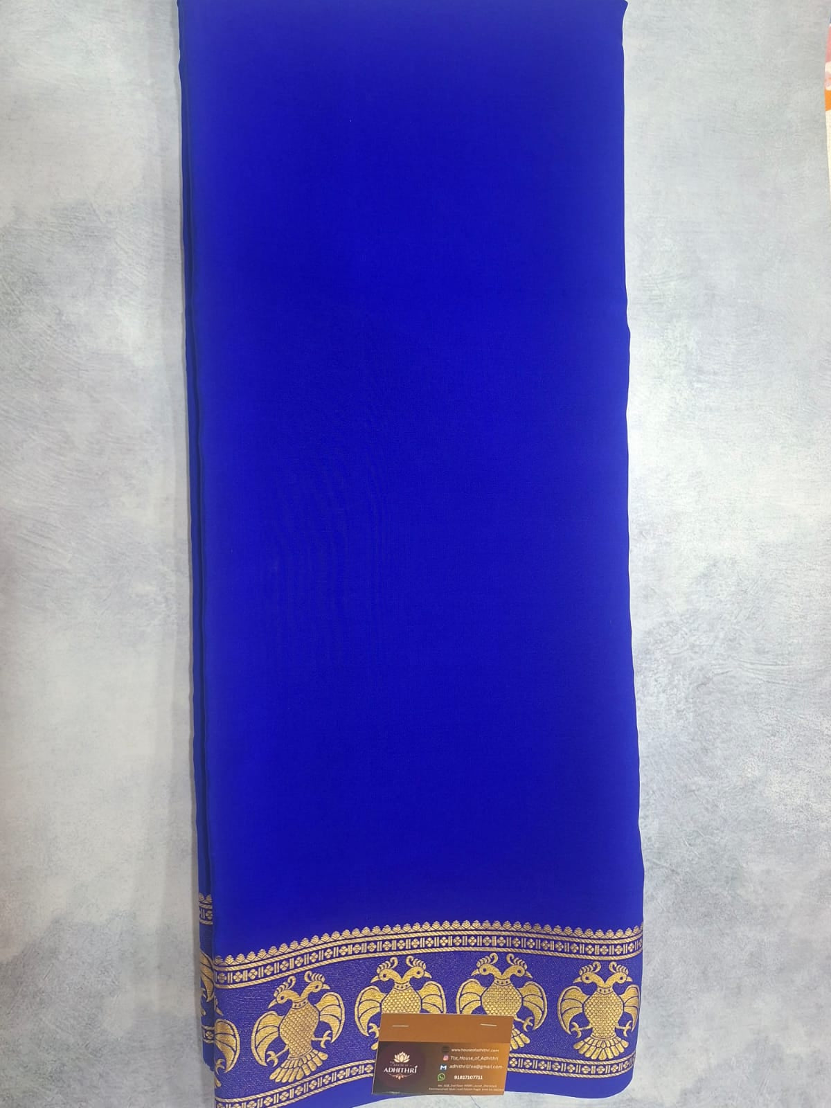 Blue mat with gold border and patterns on a light gray background