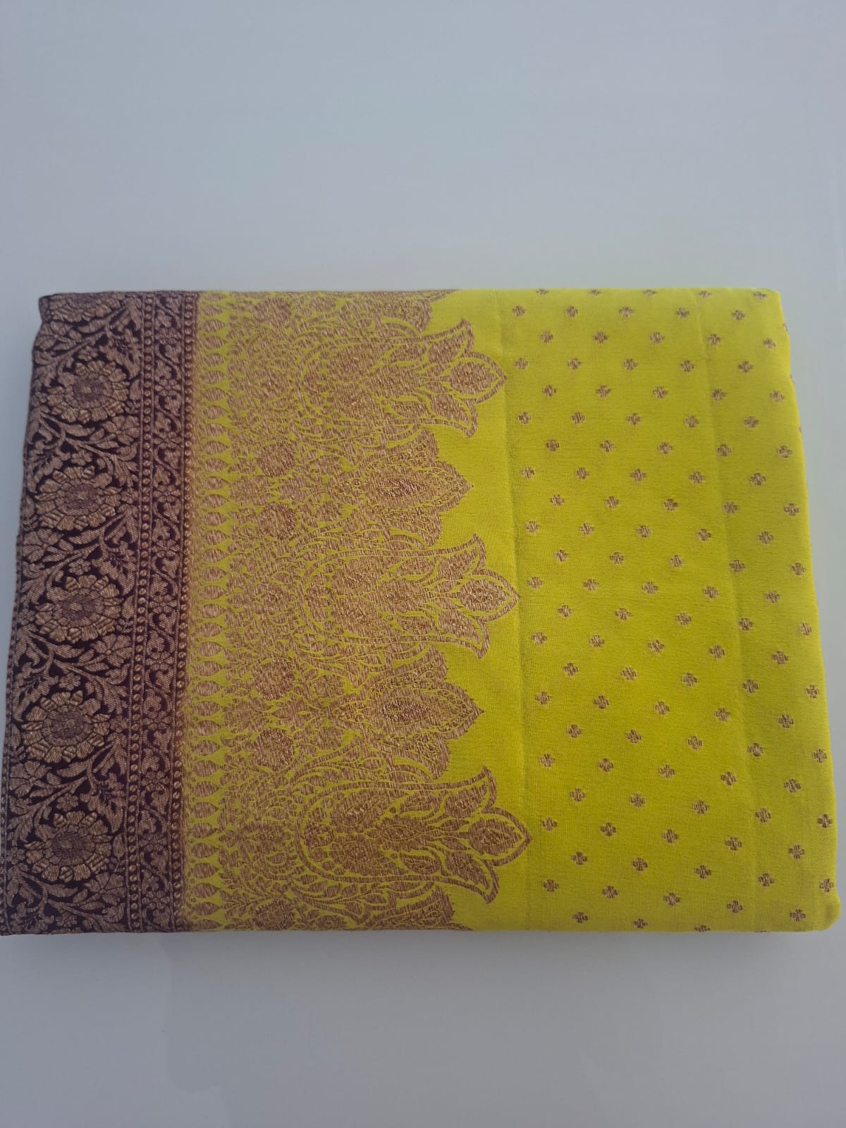 Saree with brown and yellow patterns on a white background