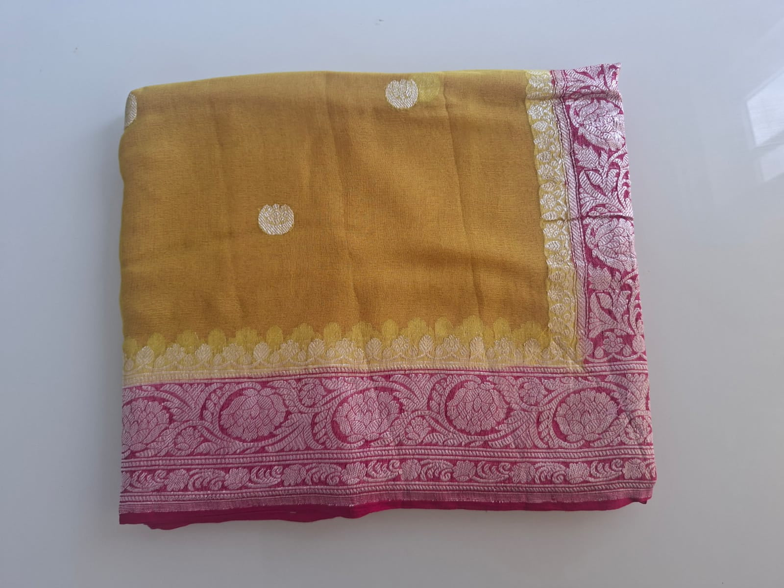 Yellow fabric with pink border on a white background