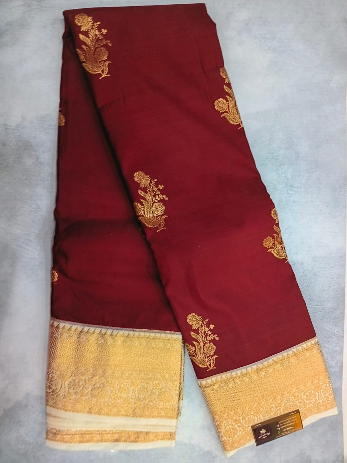 Red fabric with gold embroidery on a gray background