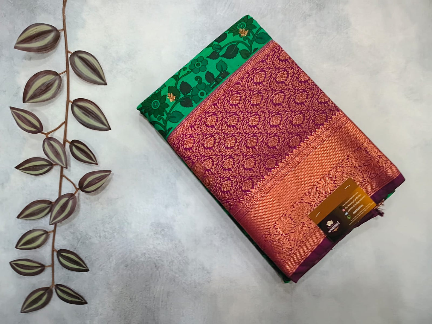Three colorful fabric swatches on a textured surface with a decorative leaf design.