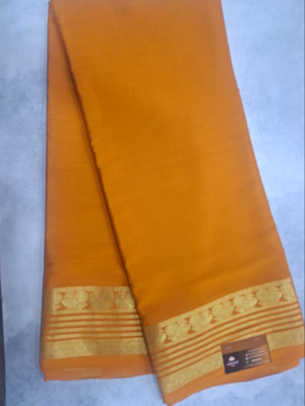 Orange fabric with gold border on a white background