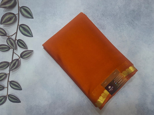 Orange fabric with gold trim on a textured surface