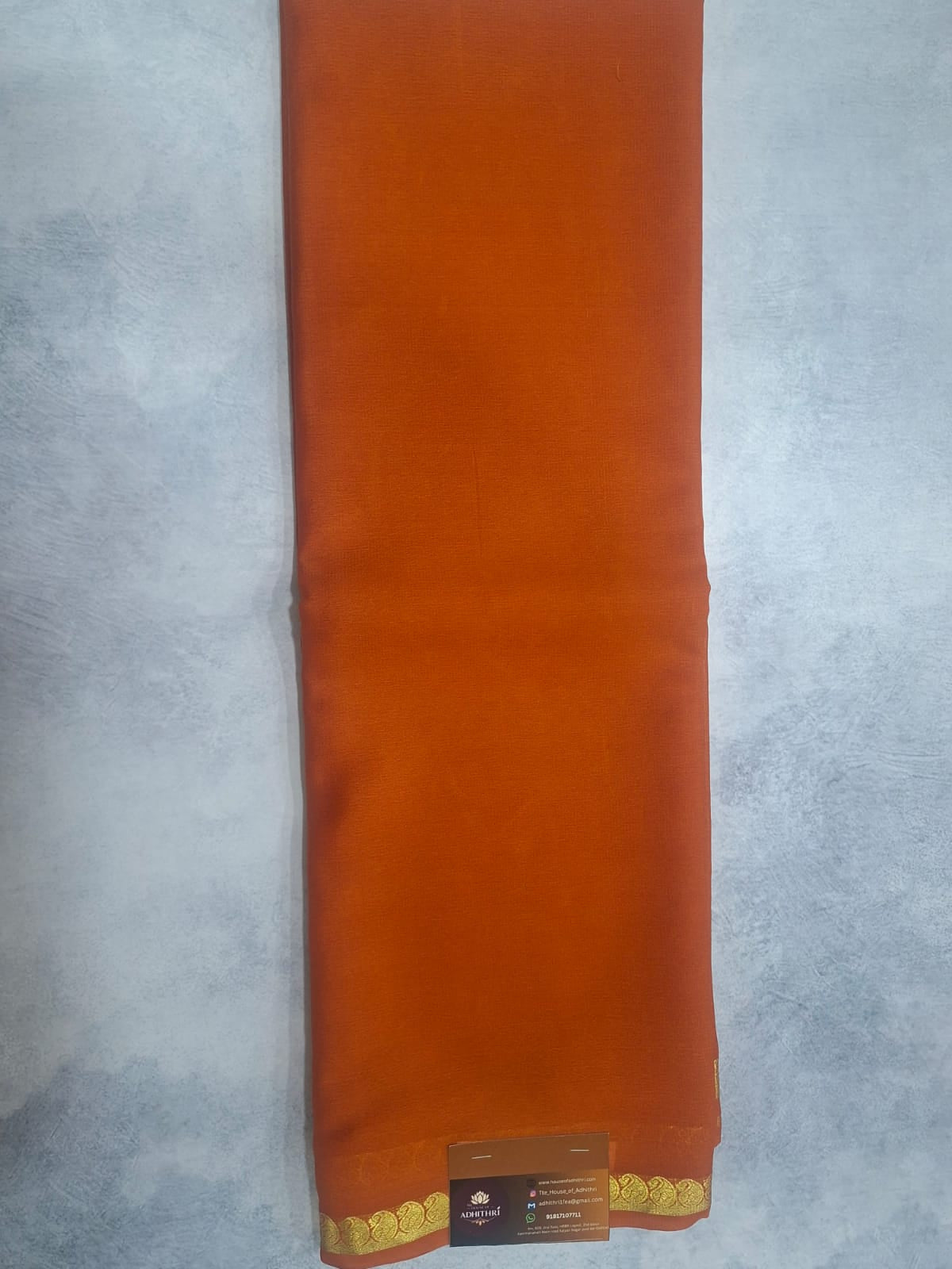 Orange fabric roll with a label on a gray background