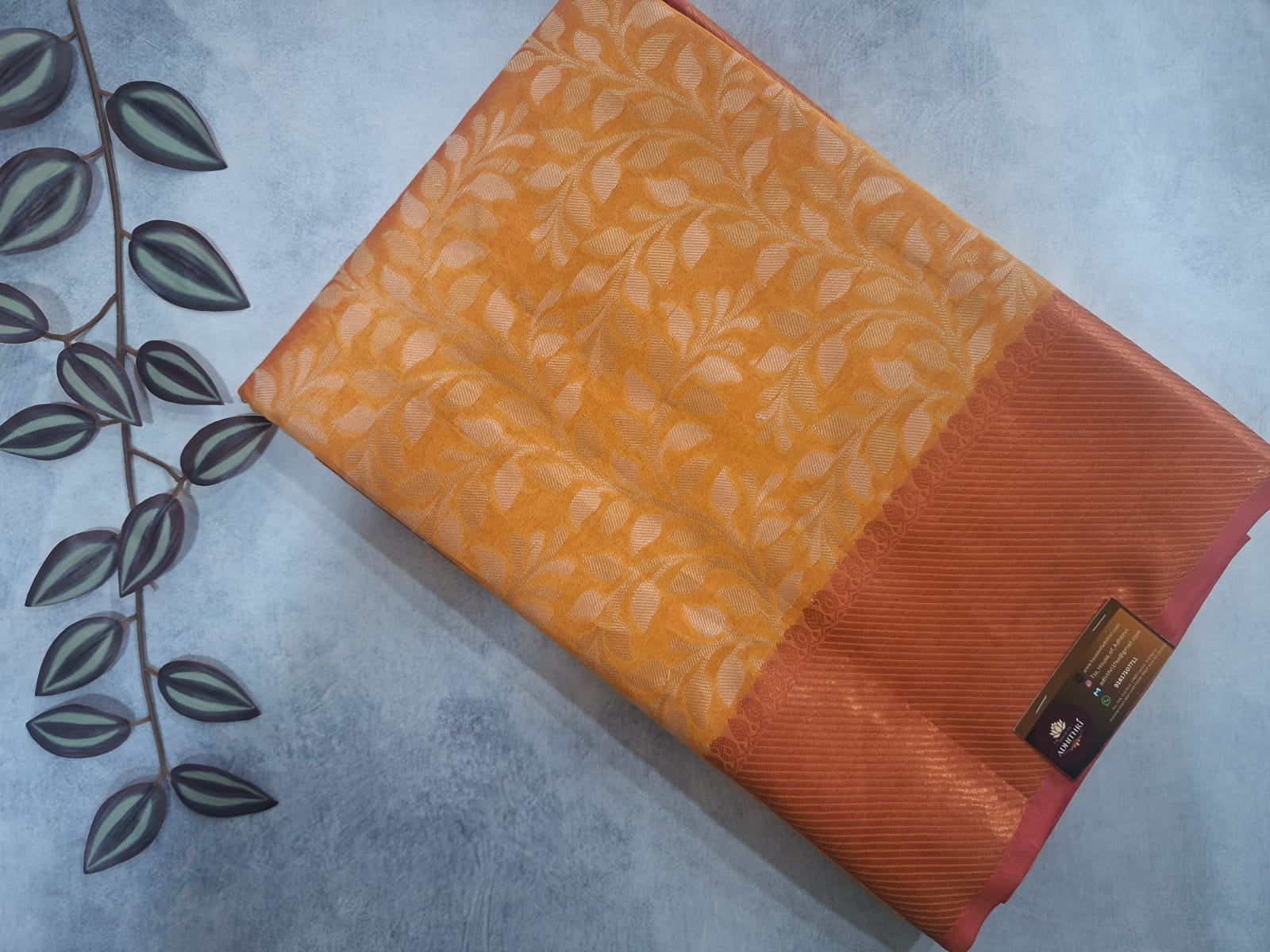 Orange fabric with leaf pattern on a gray surface