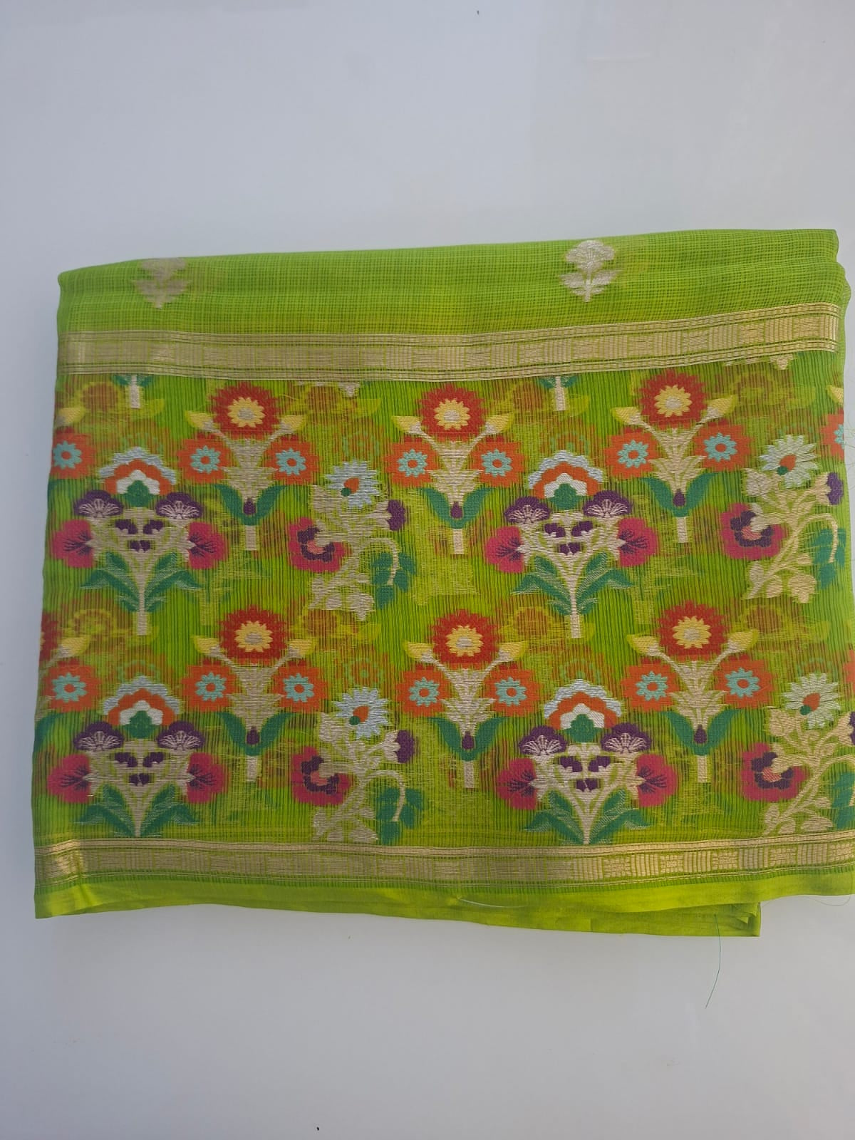 Green saree with floral patterns on a white background