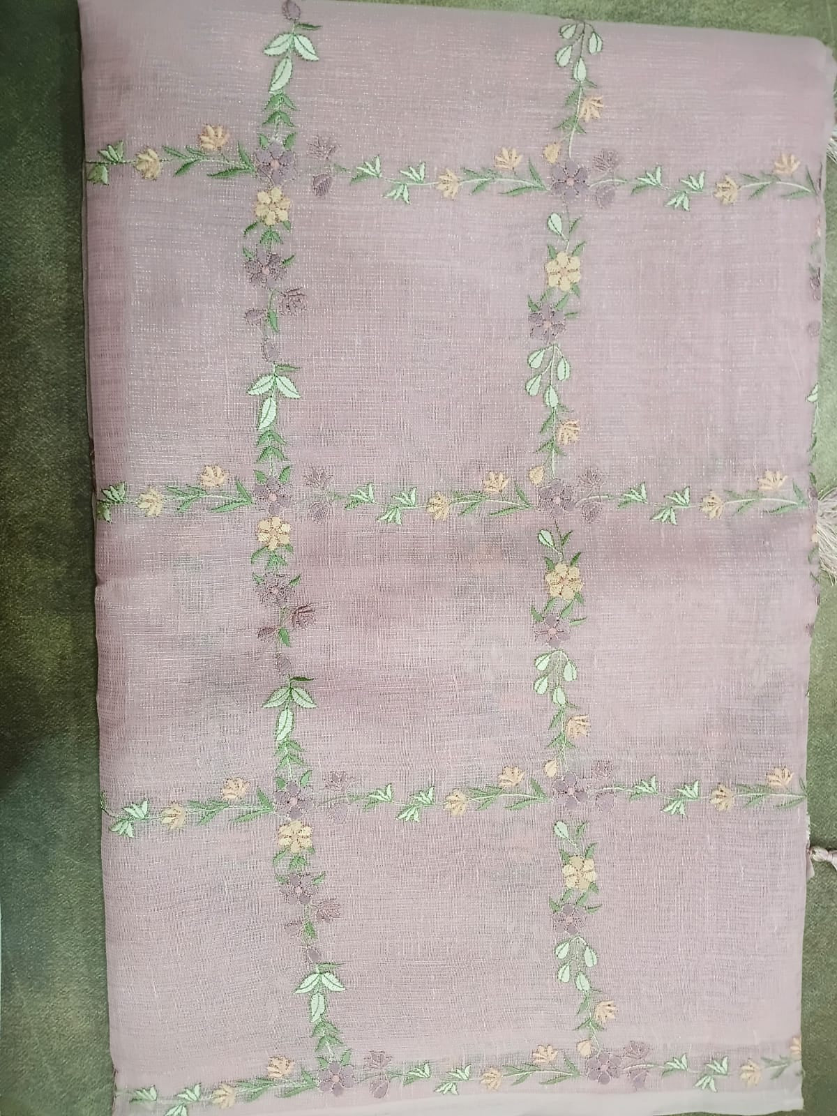 Embroidered fabric with floral patterns on a green background