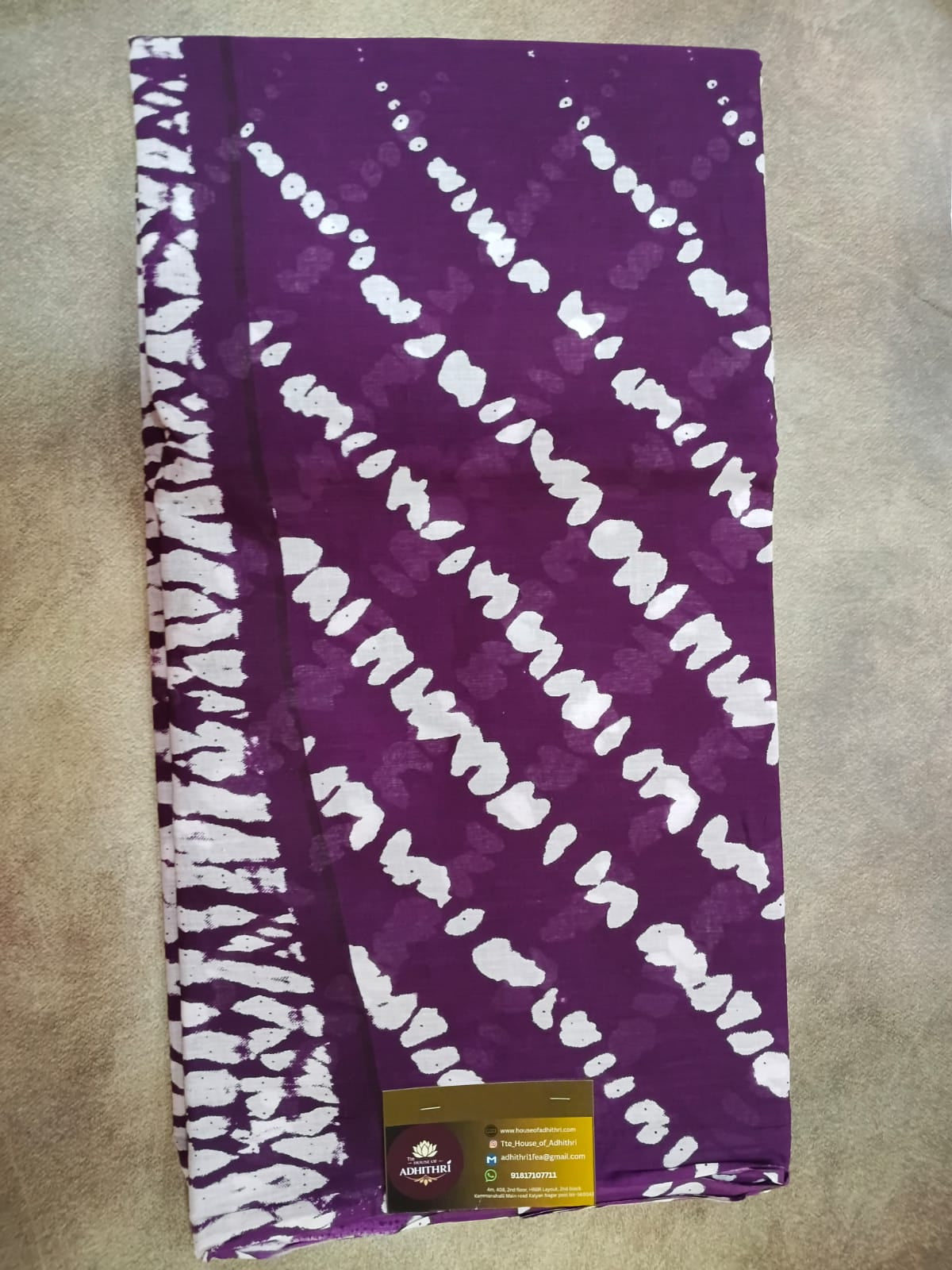 Purple fabric with white pattern on a beige surface