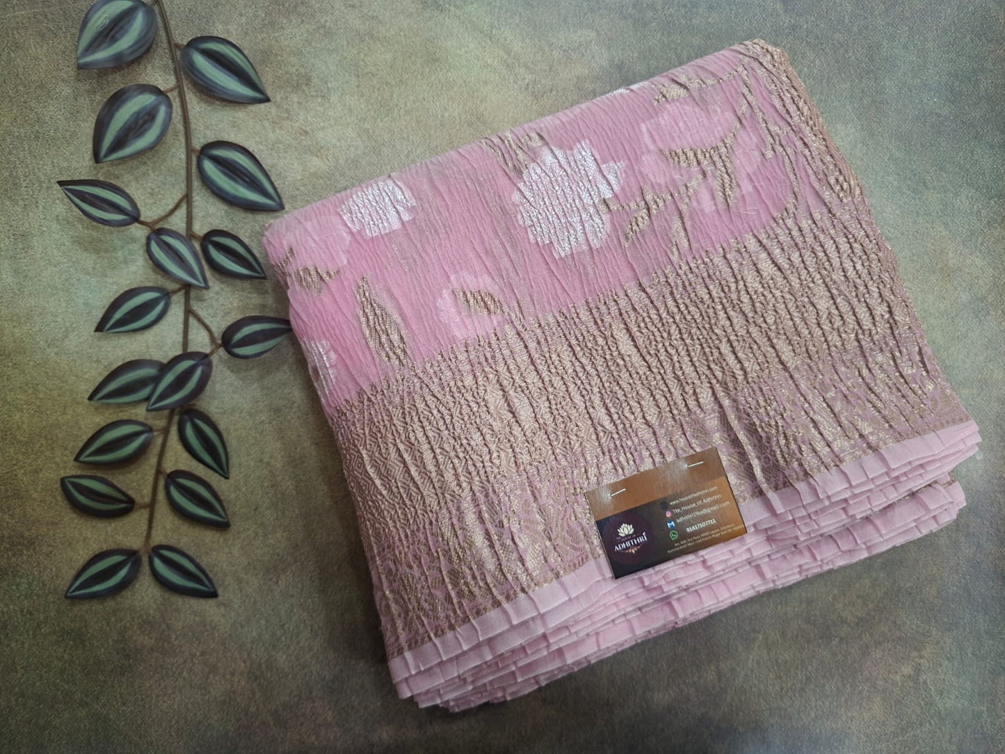 Pink textured towel with a brand label on a textured surface