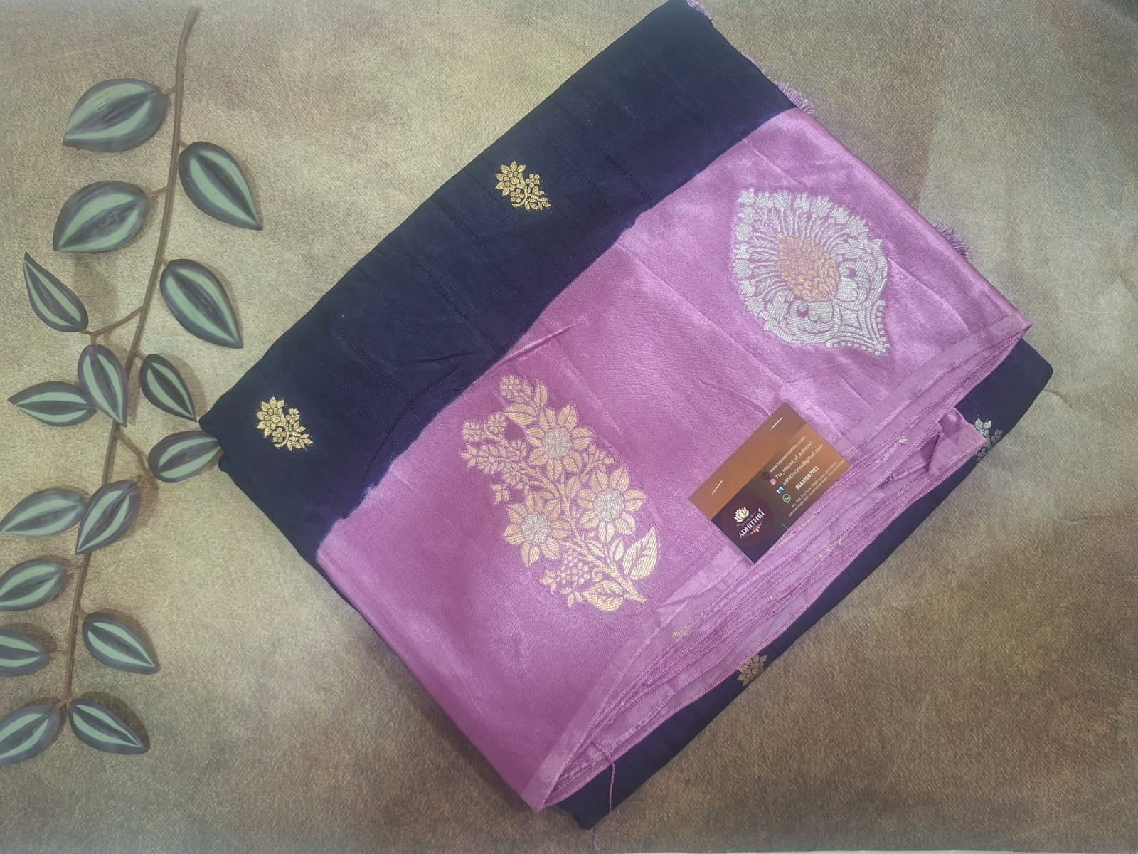 Purple saree with gold embroidery on a textured surface