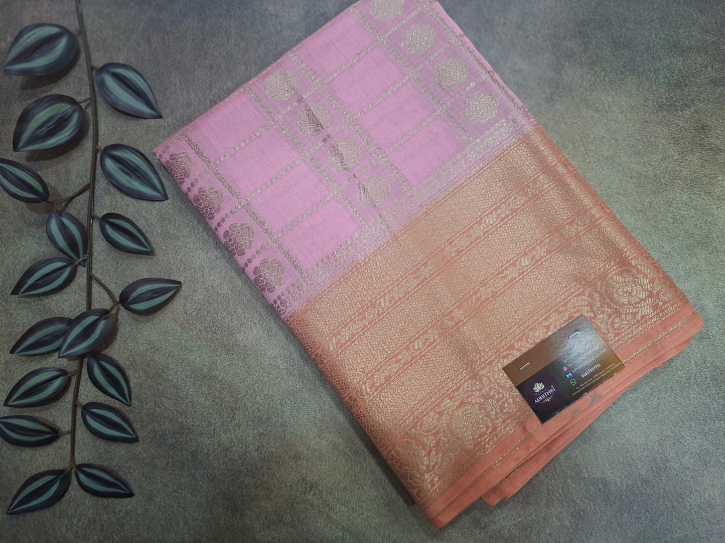 Folded pink and peach patterned fabric on a textured surface