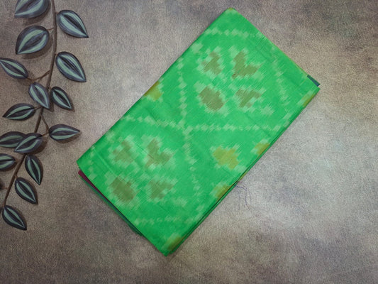 Green patterned fabric on a textured surface with leaf design