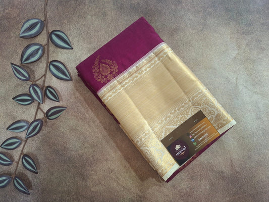 Saree with a purple border on a textured surface with leaf decorations