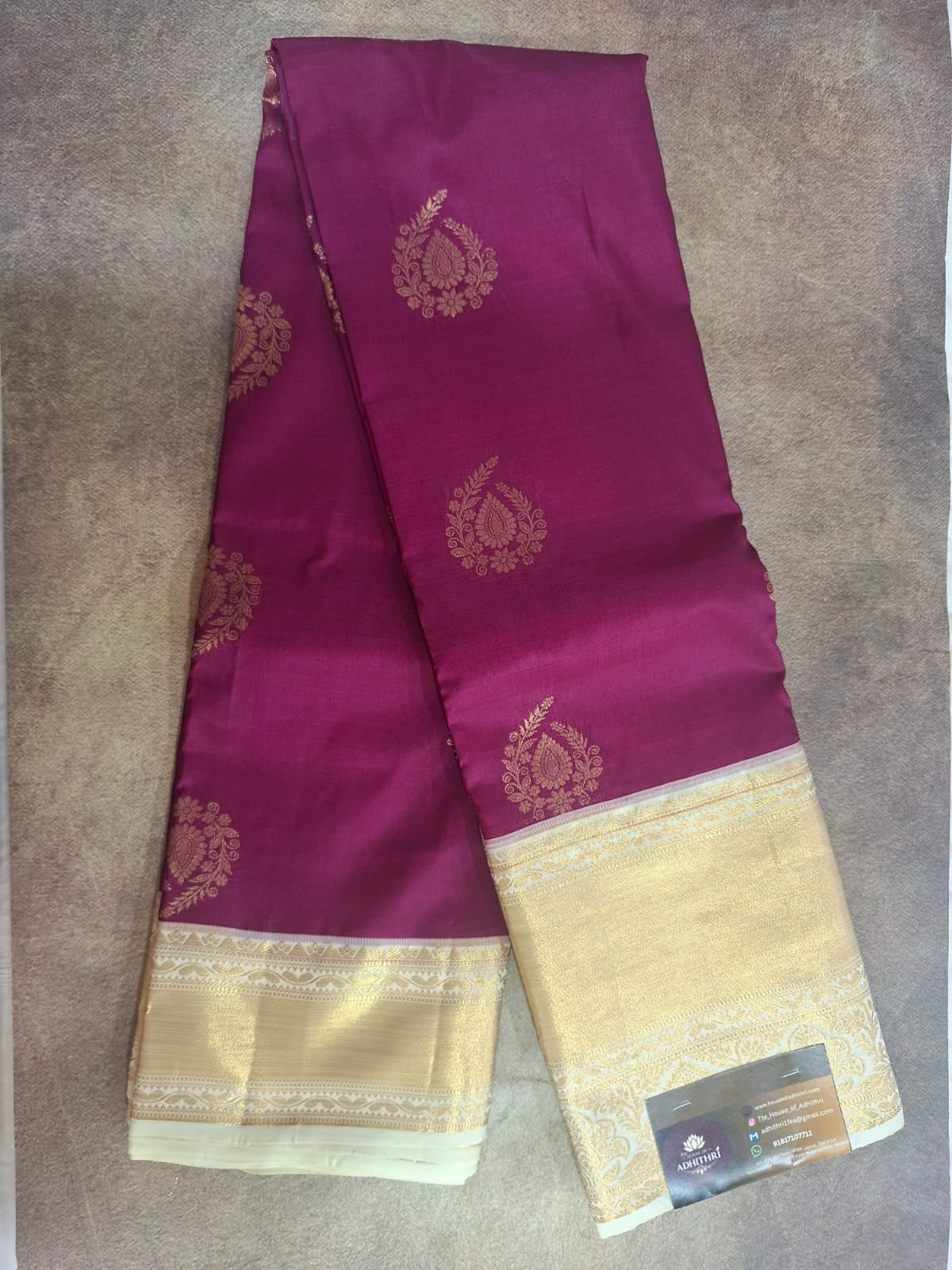 Purple saree with gold border on a brown surface