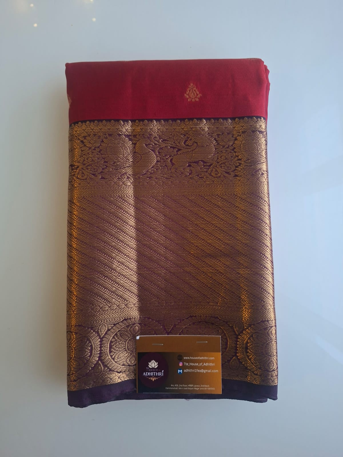 Brown fabric with red border and embroidered design on a white background