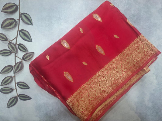 Red saree with gold border on a light gray background