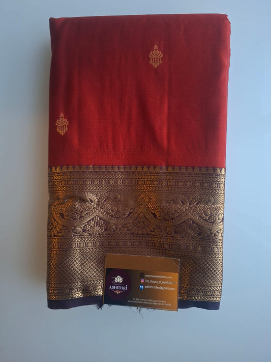 Red fabric with gold embroidery and a brand label on a light blue background