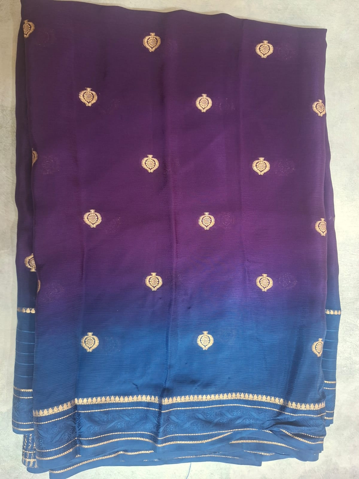 Blue and purple fabric with gold patterns on a white background