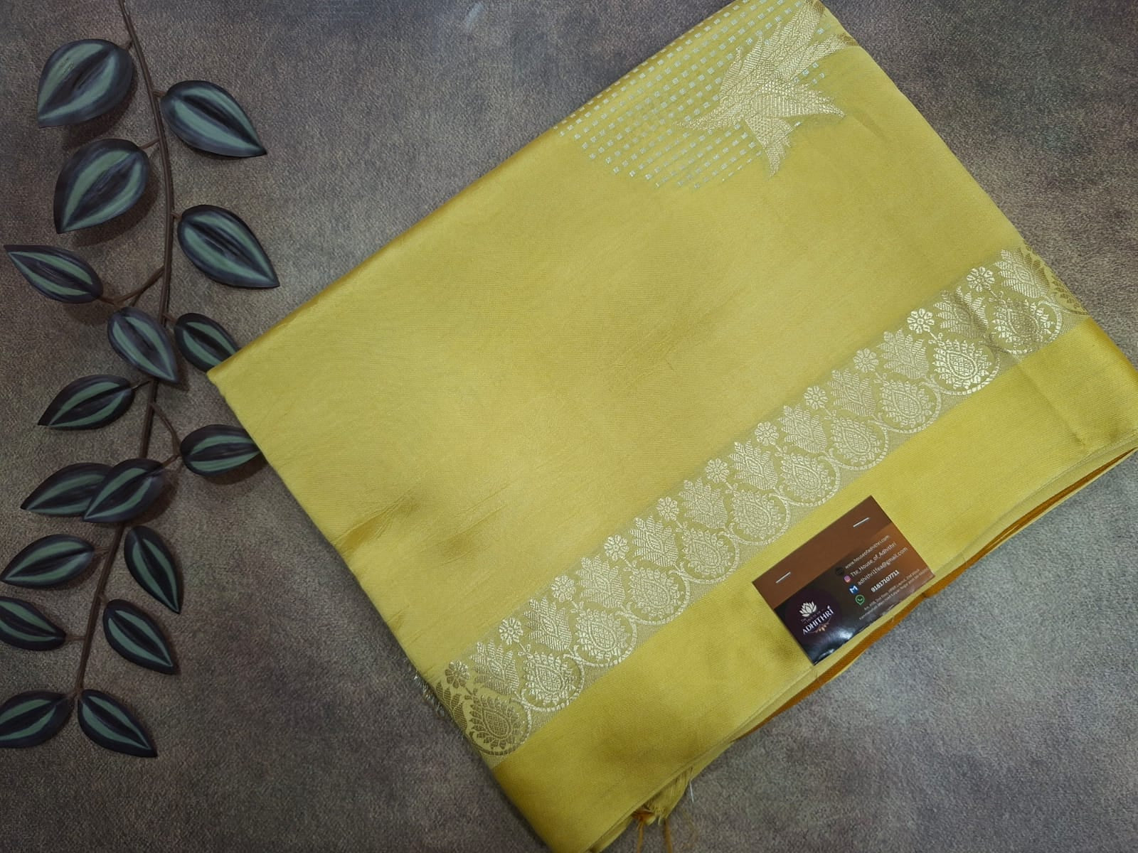 Yellow fabric with white lace border on a textured surface