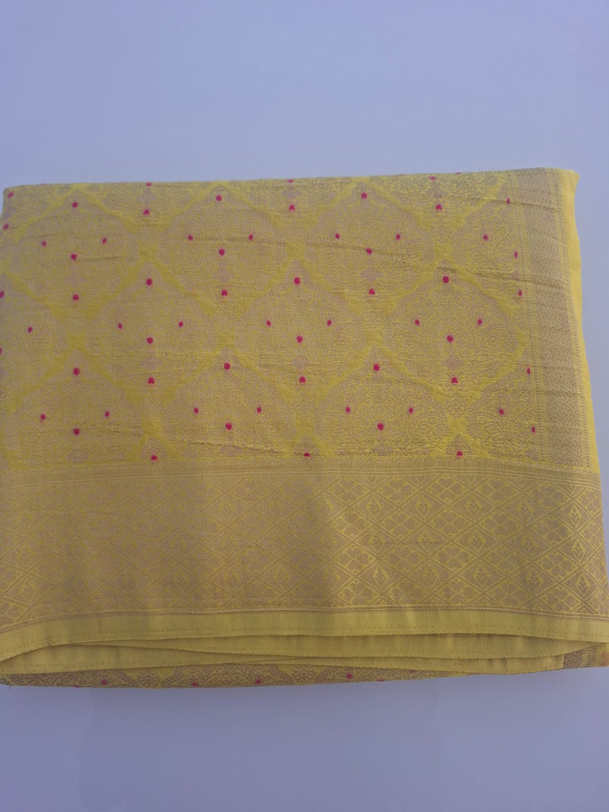 Yellow fabric with a subtle pattern on a light purple background