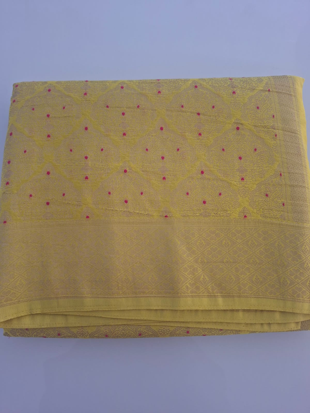 Yellow fabric with red patterns on a light purple background