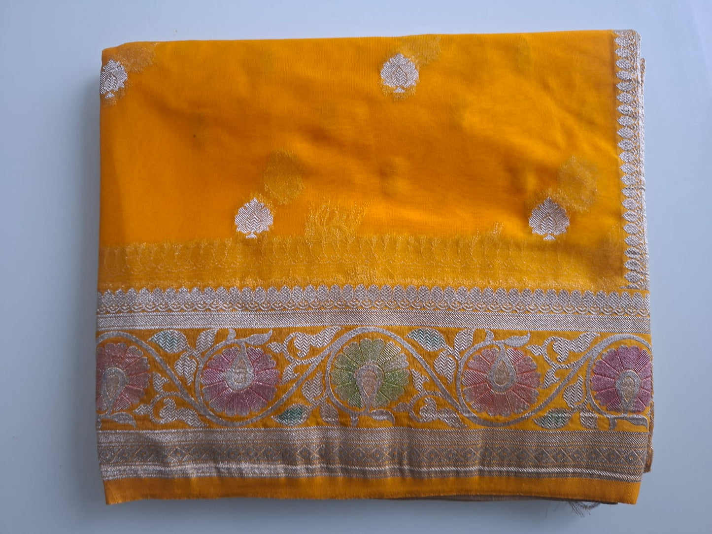 Yellow fabric with floral patterns on a light blue background