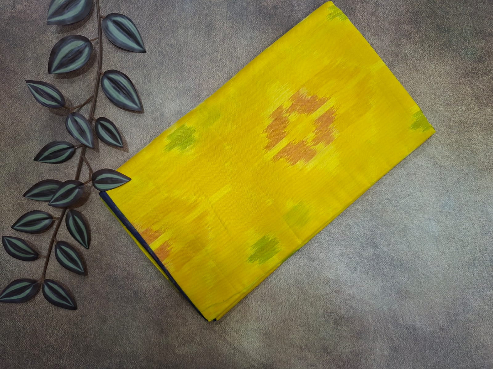Yellow fabric with floral patterns on a gray surface