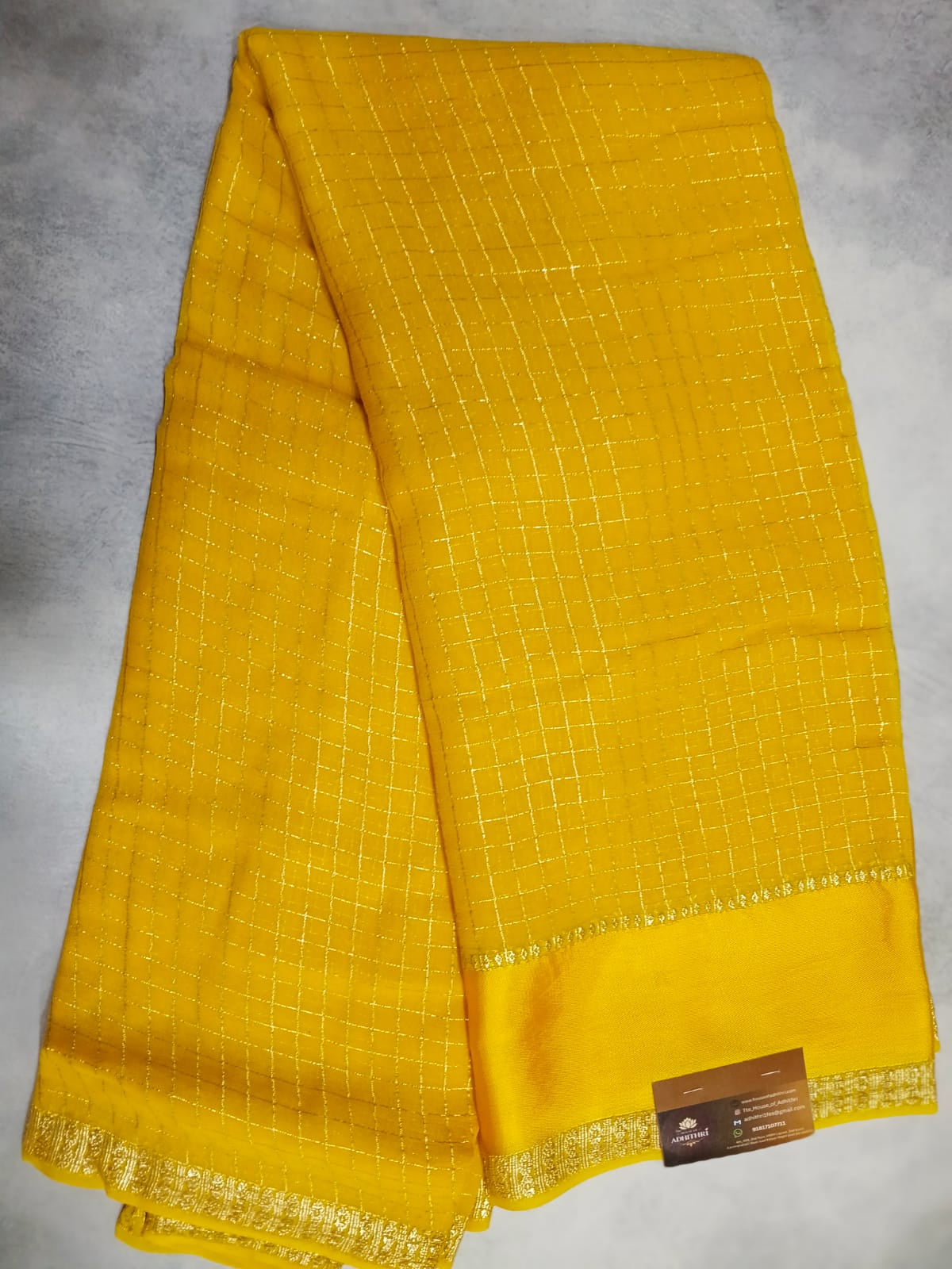 Yellow fabric with a grid pattern on a gray background